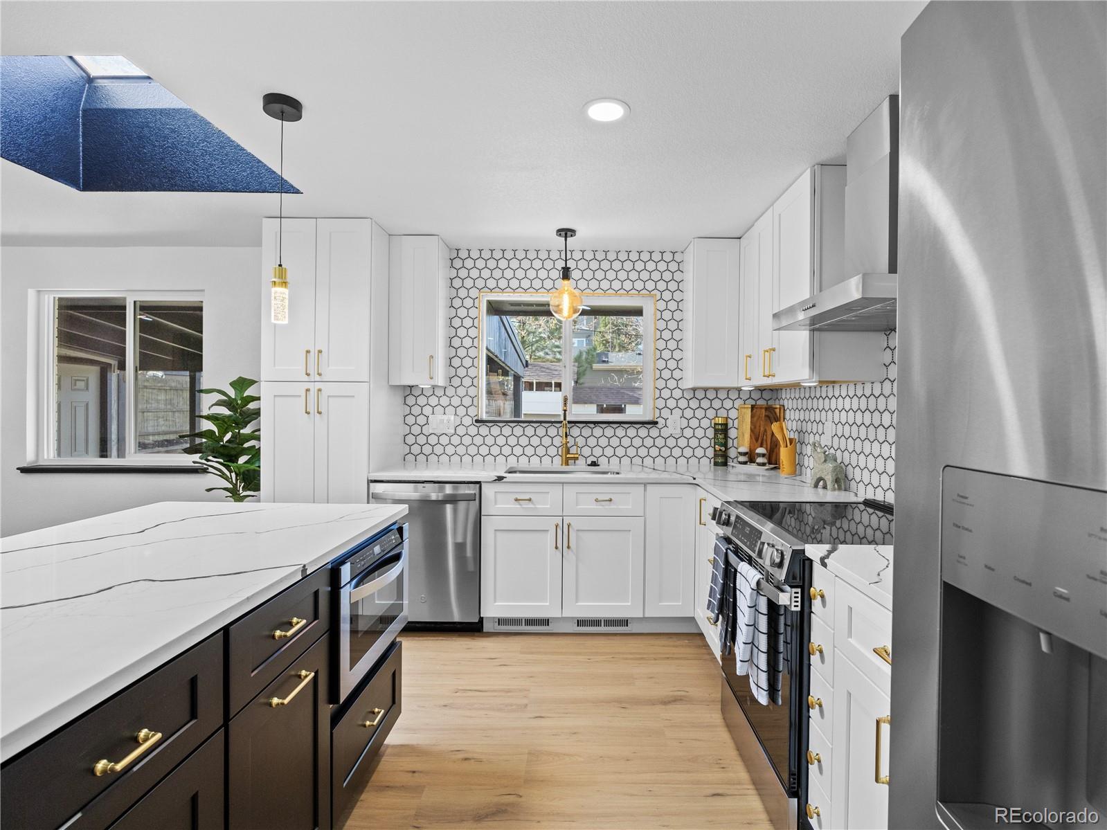 5673 Johnson Street Arvada, CO 80002 - Photo 17 of 40 a kitchen with a sink stove and cabinets