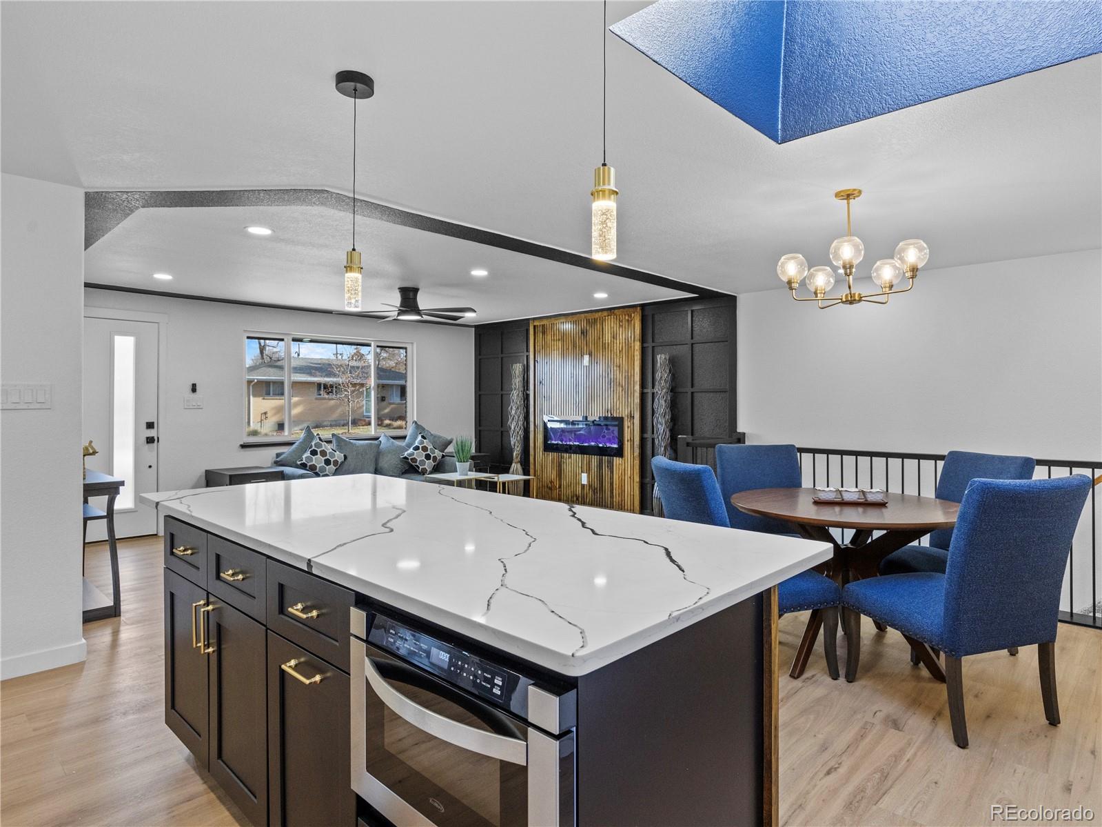 5673 Johnson Street Arvada, CO 80002 - Photo 18 of 40 a kitchen with a stove a kitchen island a table and chairs in it