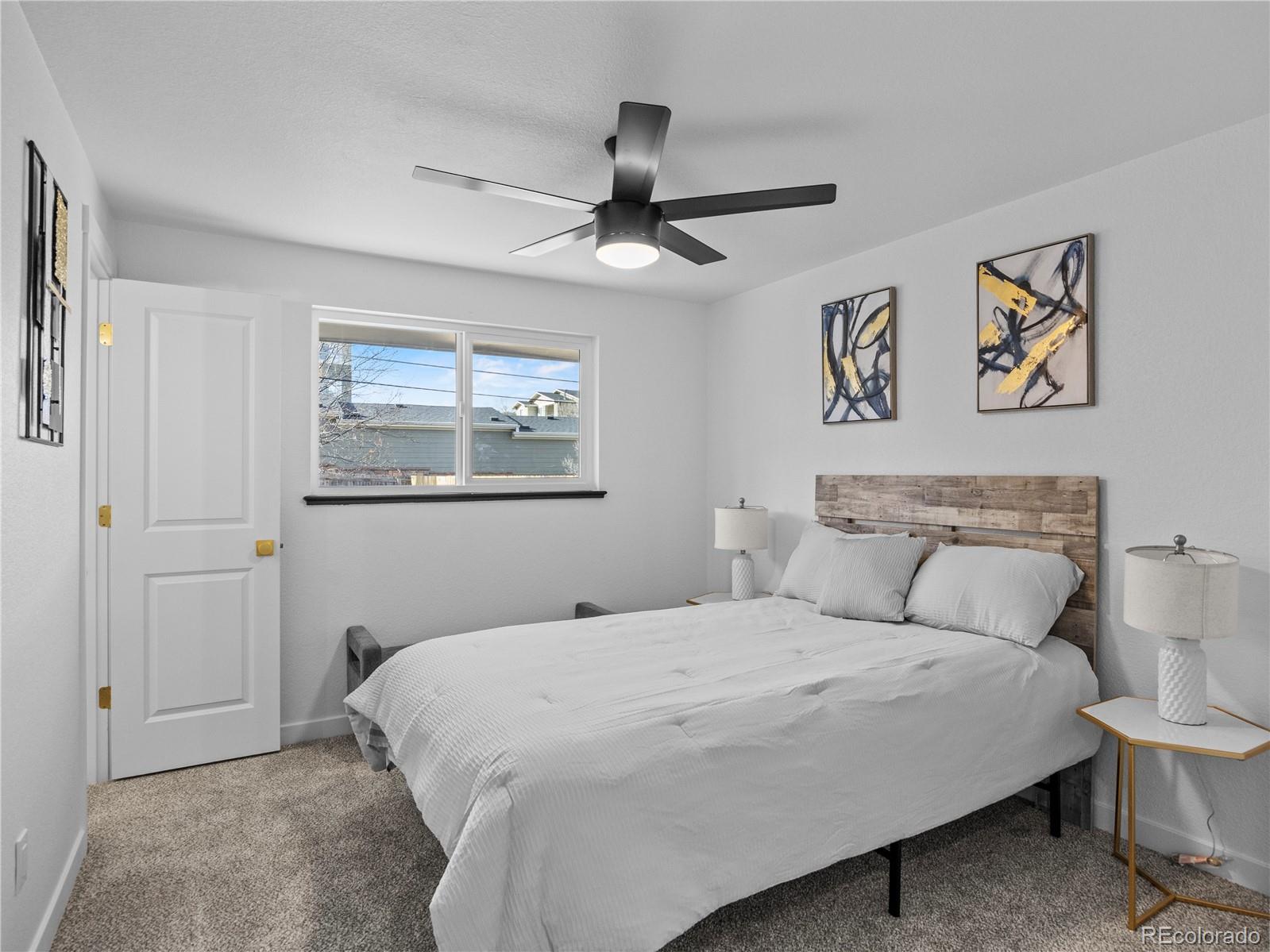 5673 Johnson Street Arvada, CO 80002 - Photo 19 of 40 a bedroom with a bed and a painting on the wall