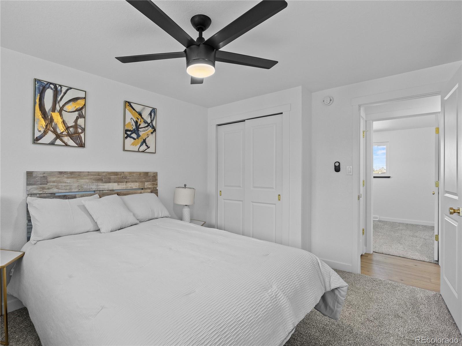 5673 Johnson Street Arvada, CO 80002 - Photo 21 of 40 a bedroom with a large bed and a chandelier