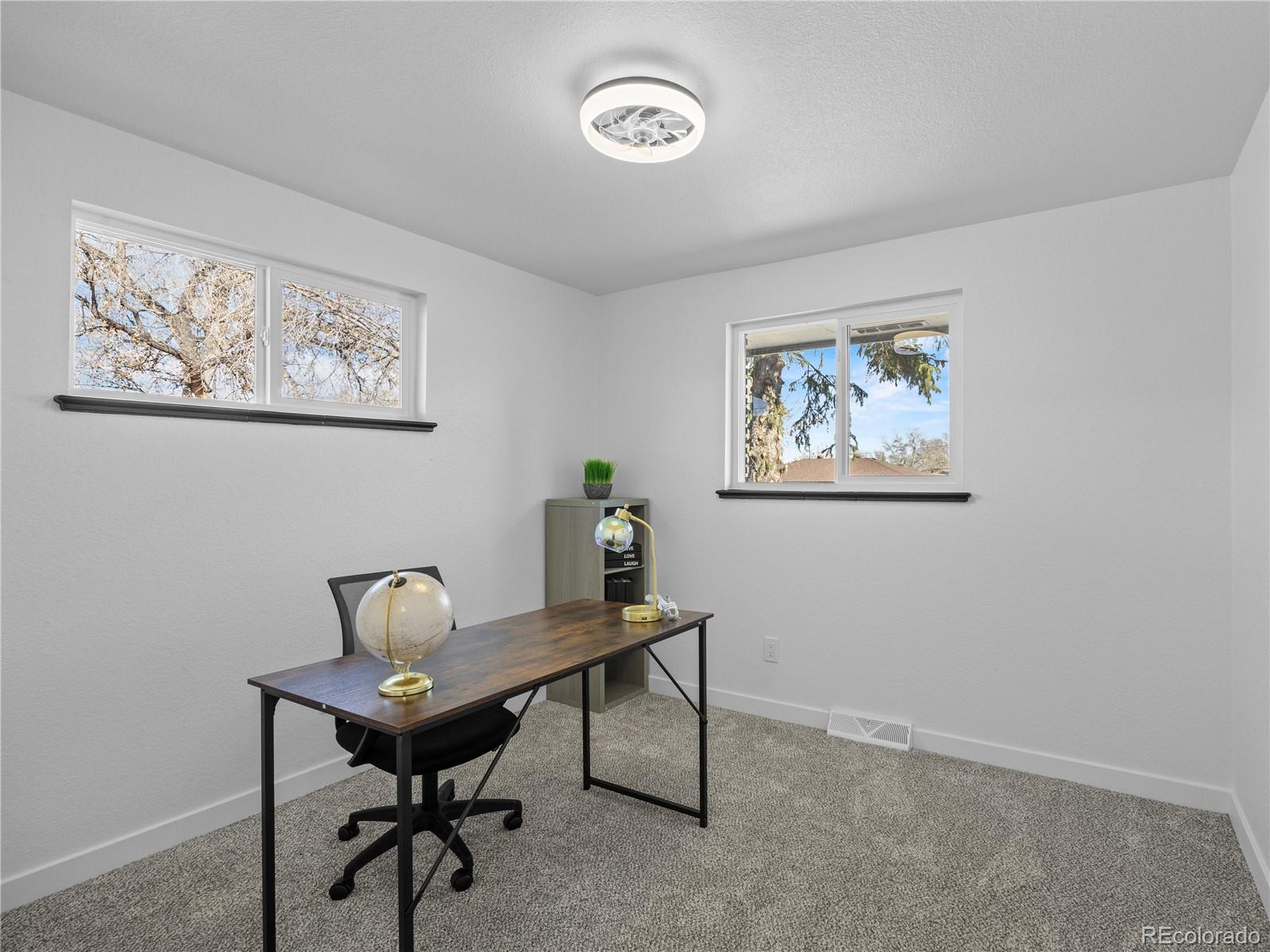 5673 Johnson Street Arvada, CO 80002 - Photo 23 of 40 a view of a workspace with a table and couch