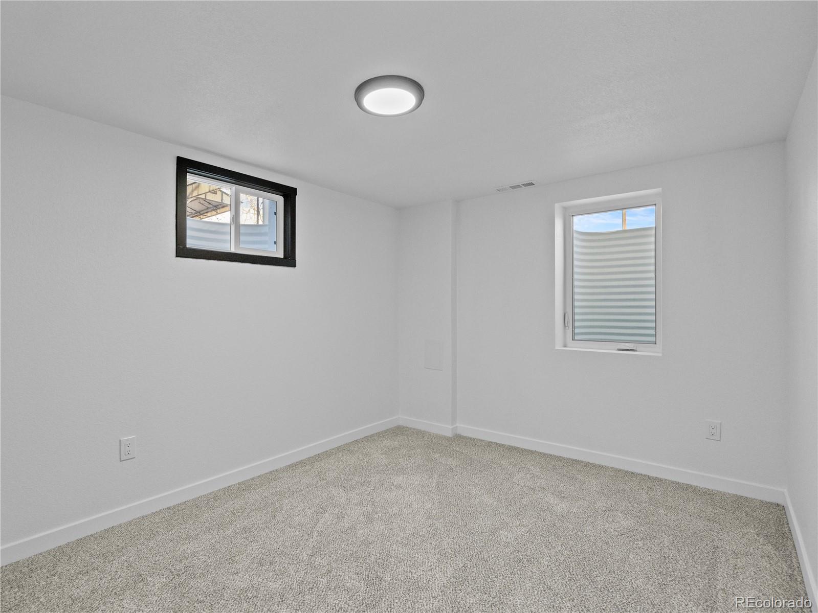 5673 Johnson Street Arvada, CO 80002 - Photo 29 of 40 an empty room with windows