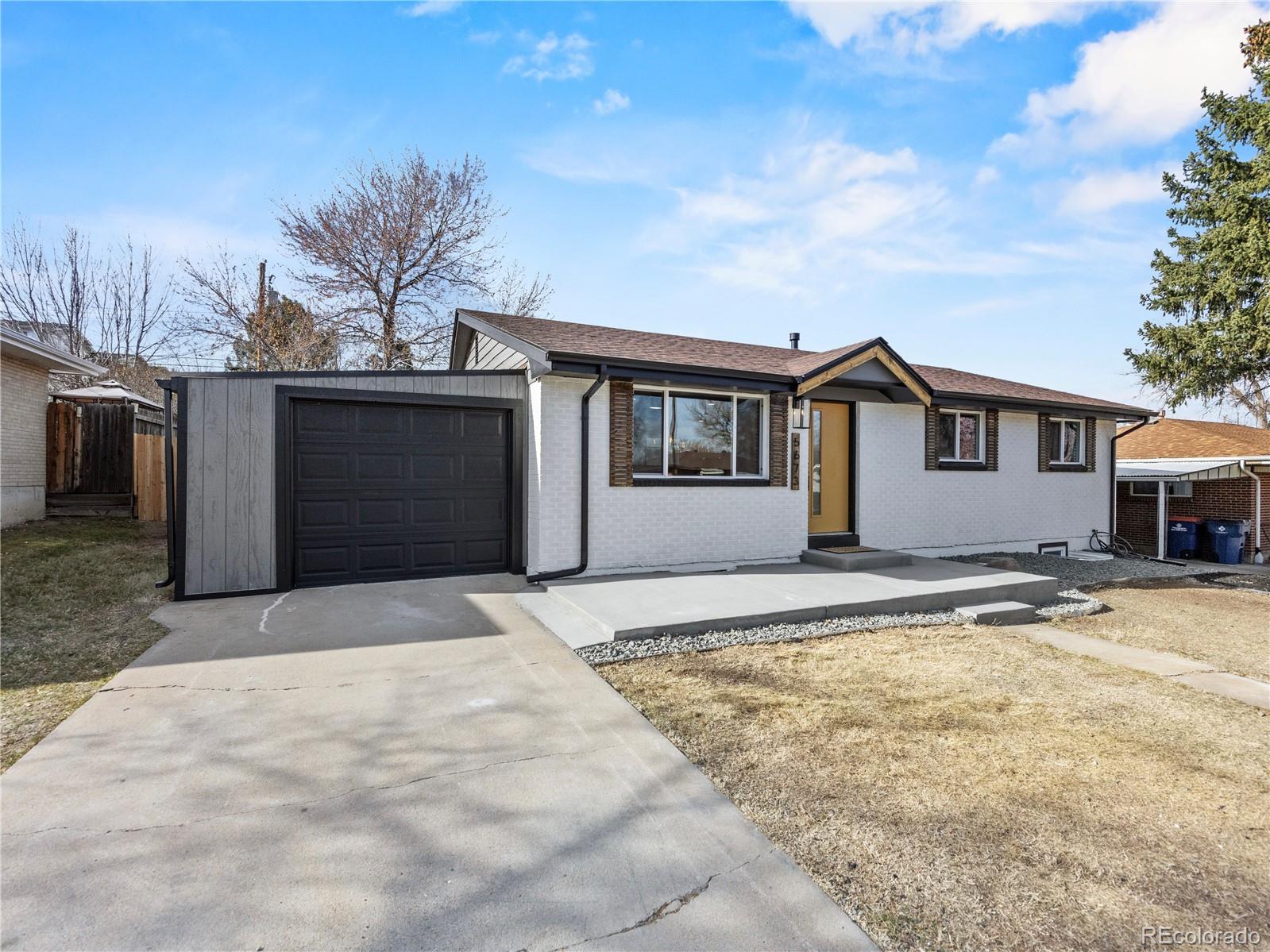 5673 Johnson Street Arvada, CO 80002 - Photo 3 of 40 a view of a house with a backyard and a garage