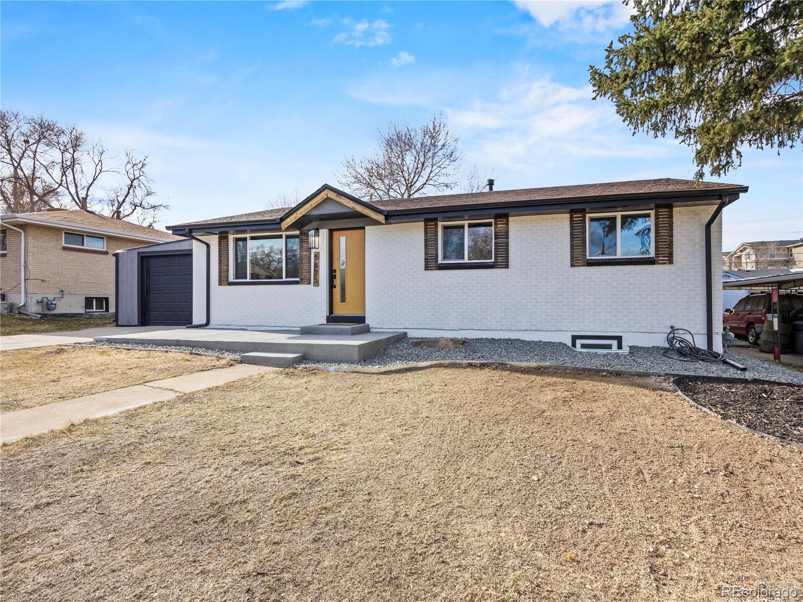 5673 Johnson Street Arvada, CO 80002 - Photo 4 of 40 a front view of a house with a yard