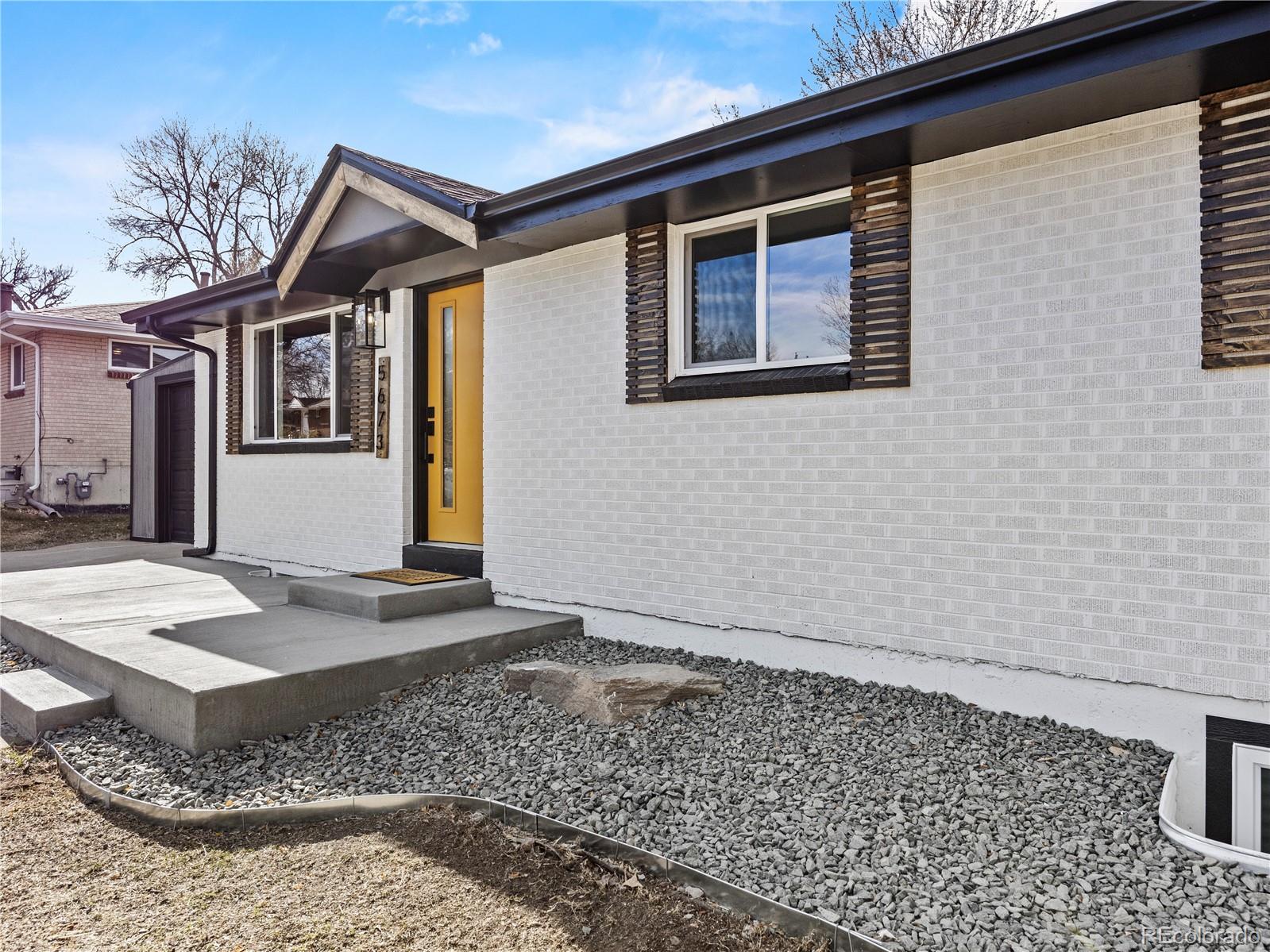 5673 Johnson Street Arvada, CO 80002 - Photo 5 of 40 a front view of a house with a yard