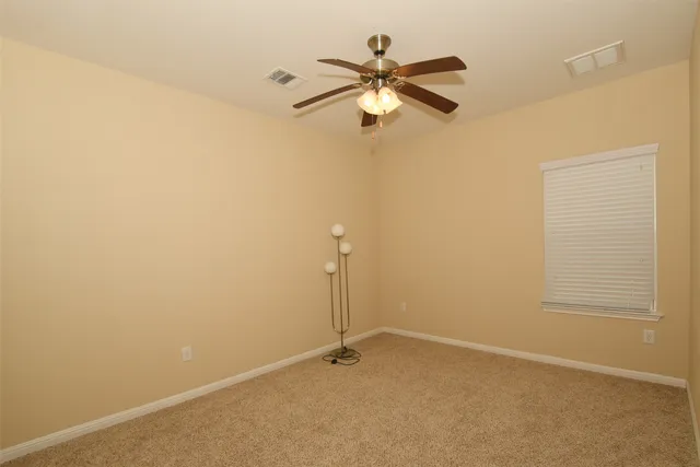 an empty room with a window and a fan