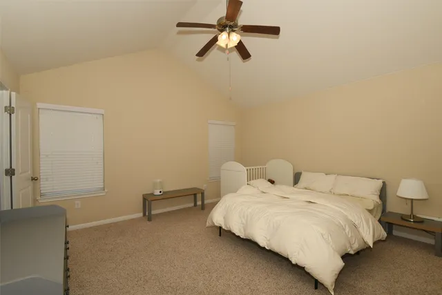 a bedroom with a bed and a ceiling fan