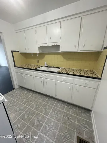 a kitchen with a sink a stove and cabinets