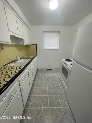 a kitchen with a sink stove and cabinets