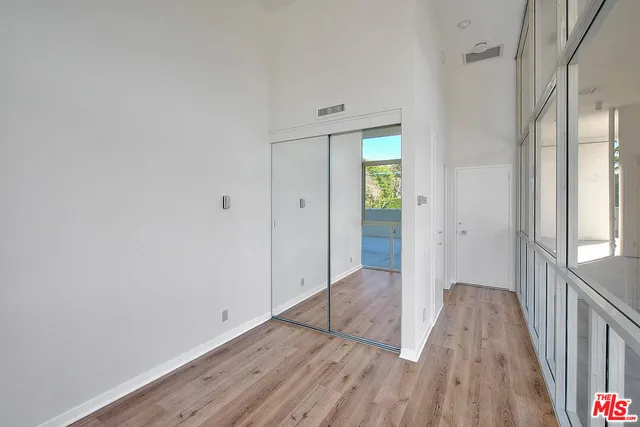 a view of a hallway with wooden floor and a bathroom
