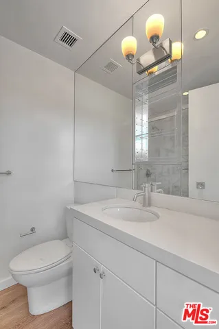 a bathroom with a sink a toilet and a mirror