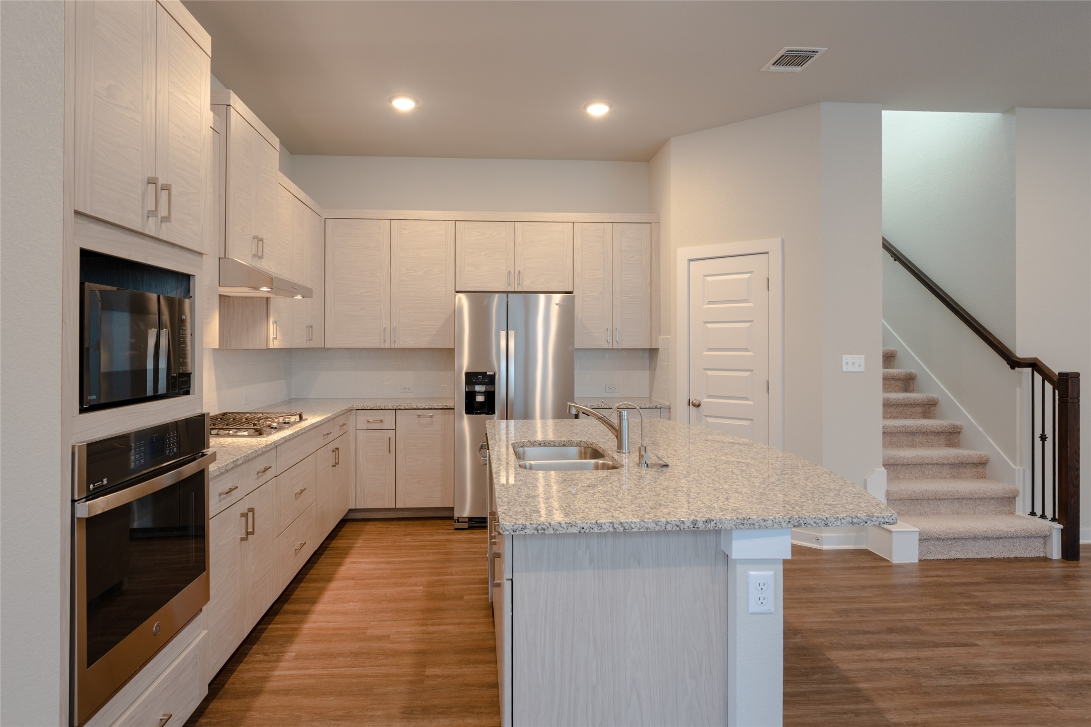 133 High Plains Drive Georgetown, TX 78628 - Photo 14 of 38 a large kitchen with kitchen island a stove a sink and a refrigerator