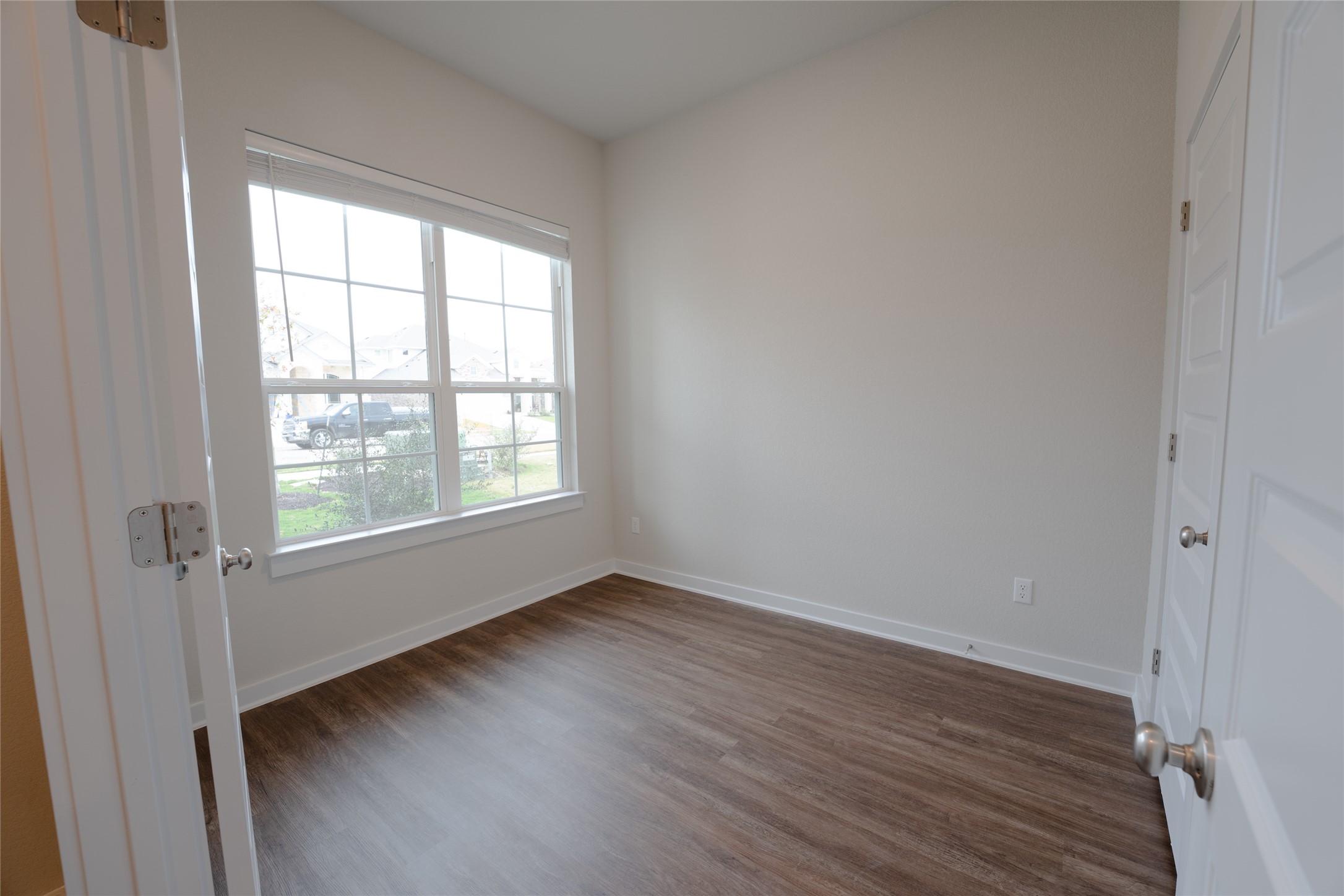 133 High Plains Drive Georgetown, TX 78628 - Photo 7 of 38 a view of an empty room with wooden floor and a window