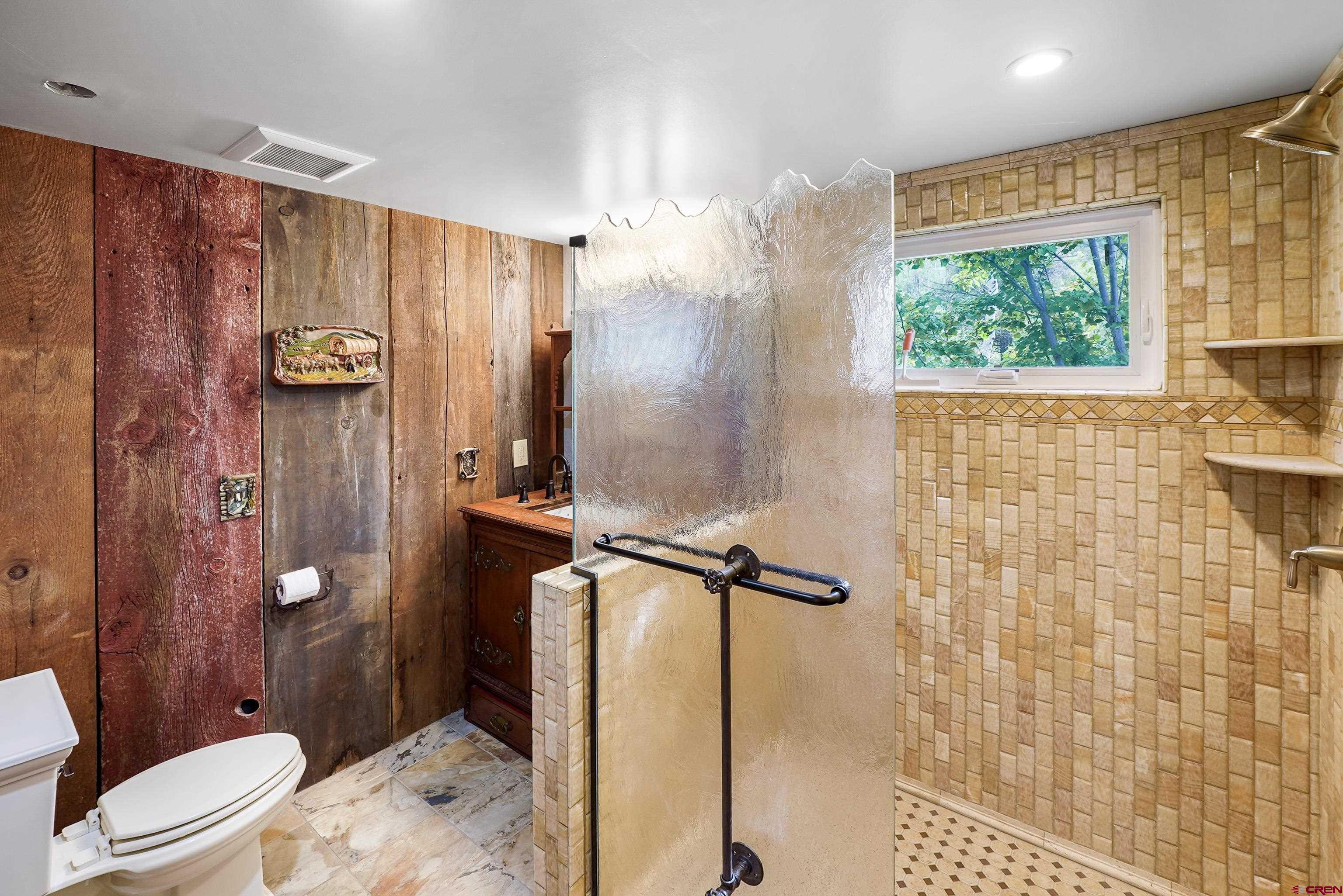 4462 County Road 124 Durango, CO 81301 - Photo 26 of 44 a bathroom with a granite countertop sink a toilet a mirror and shower