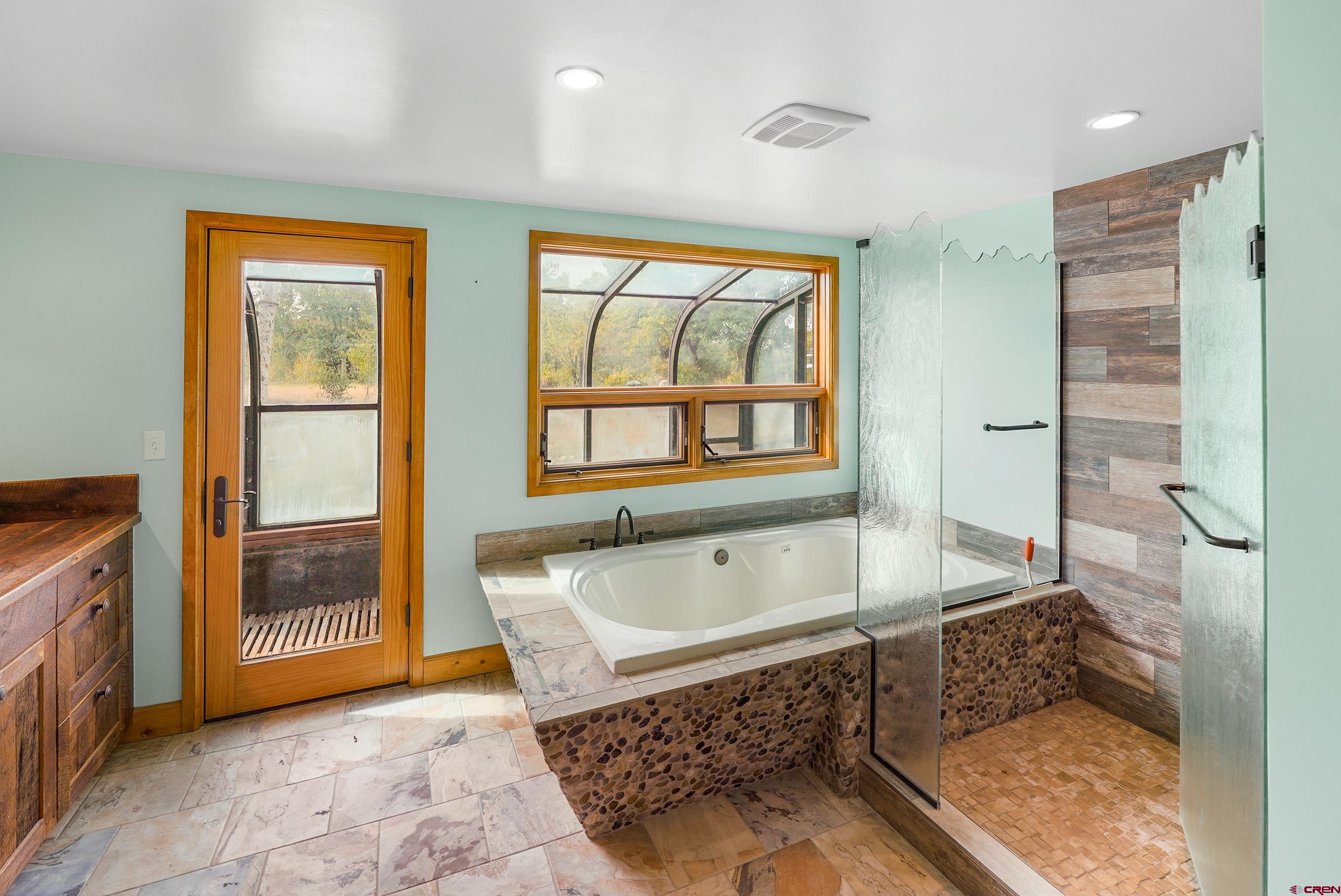 4462 County Road 124 Durango, CO 81301 - Photo 8 of 44 a bathroom with a tub a sink and a large mirror