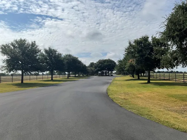 a view of swimming pool with outdoor seating and trees in the background