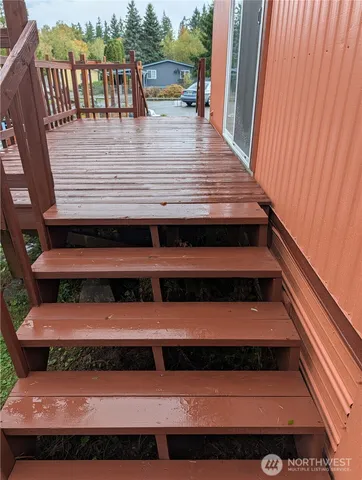 a view of a balcony with wooden floor and outdoor seating