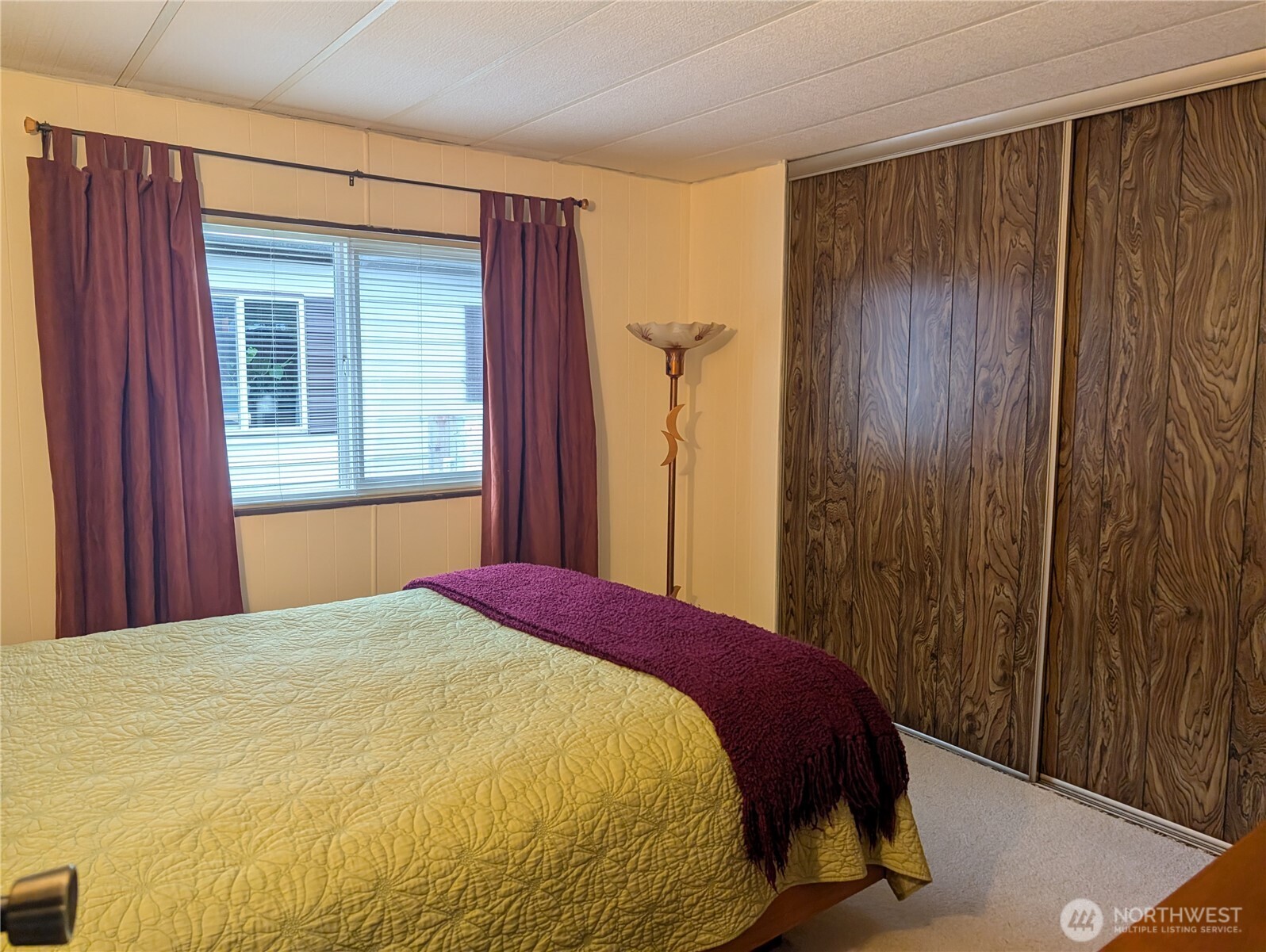 4000 Flynn Street, Unit 50 Bellingham, WA 98229 - Photo 8 of 15 a bed sitting in a bedroom next to a wooden door