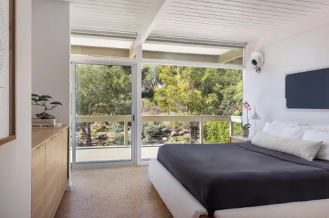 a bedroom with a bed and a large window