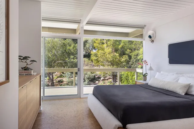 a bedroom with a bed and a large window