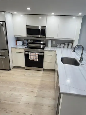 a kitchen with stainless steel appliances kitchen island granite countertop a refrigerator and a stove top oven