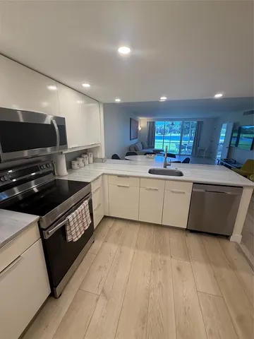 a large kitchen with stainless steel appliances kitchen island granite countertop a sink and cabinets