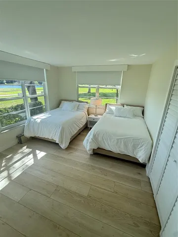 a bedroom with two beds and a large window
