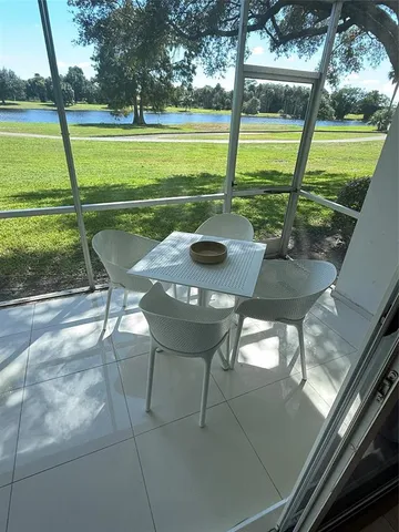 a view of a porch with furniture and a yard