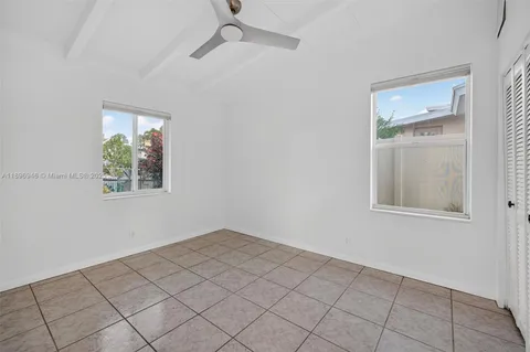 a view of an empty room and chandelier fan