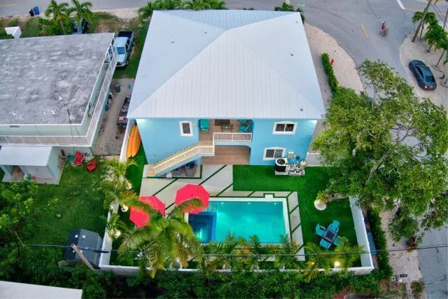 a view of a house with pool and chairs