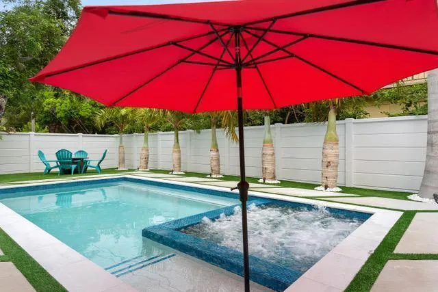 a view of a house with pool and chairs