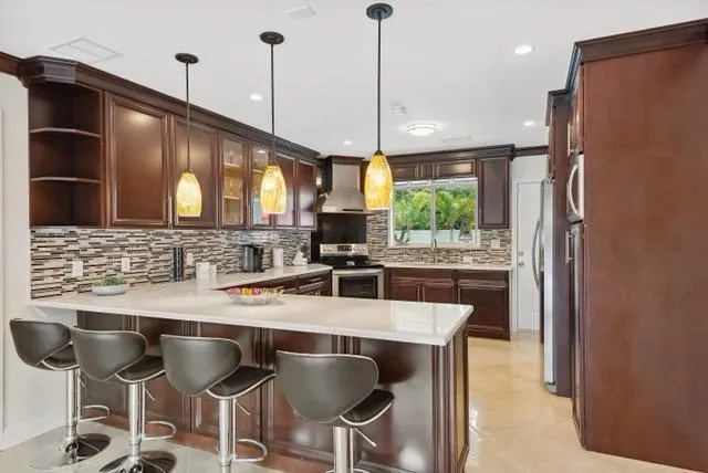 a kitchen with stainless steel appliances granite countertop a sink a stove and a refrigerator