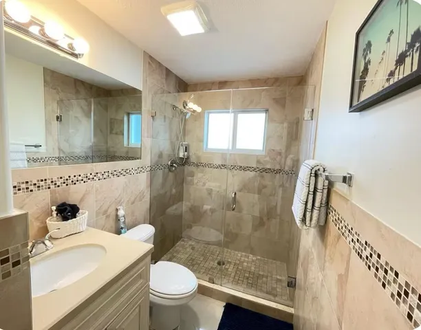 a bathroom with a sink a toilet and shower