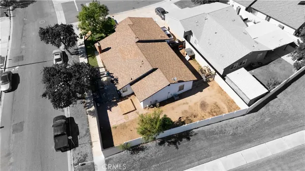 an aerial view of a house with a yard and wooden deck