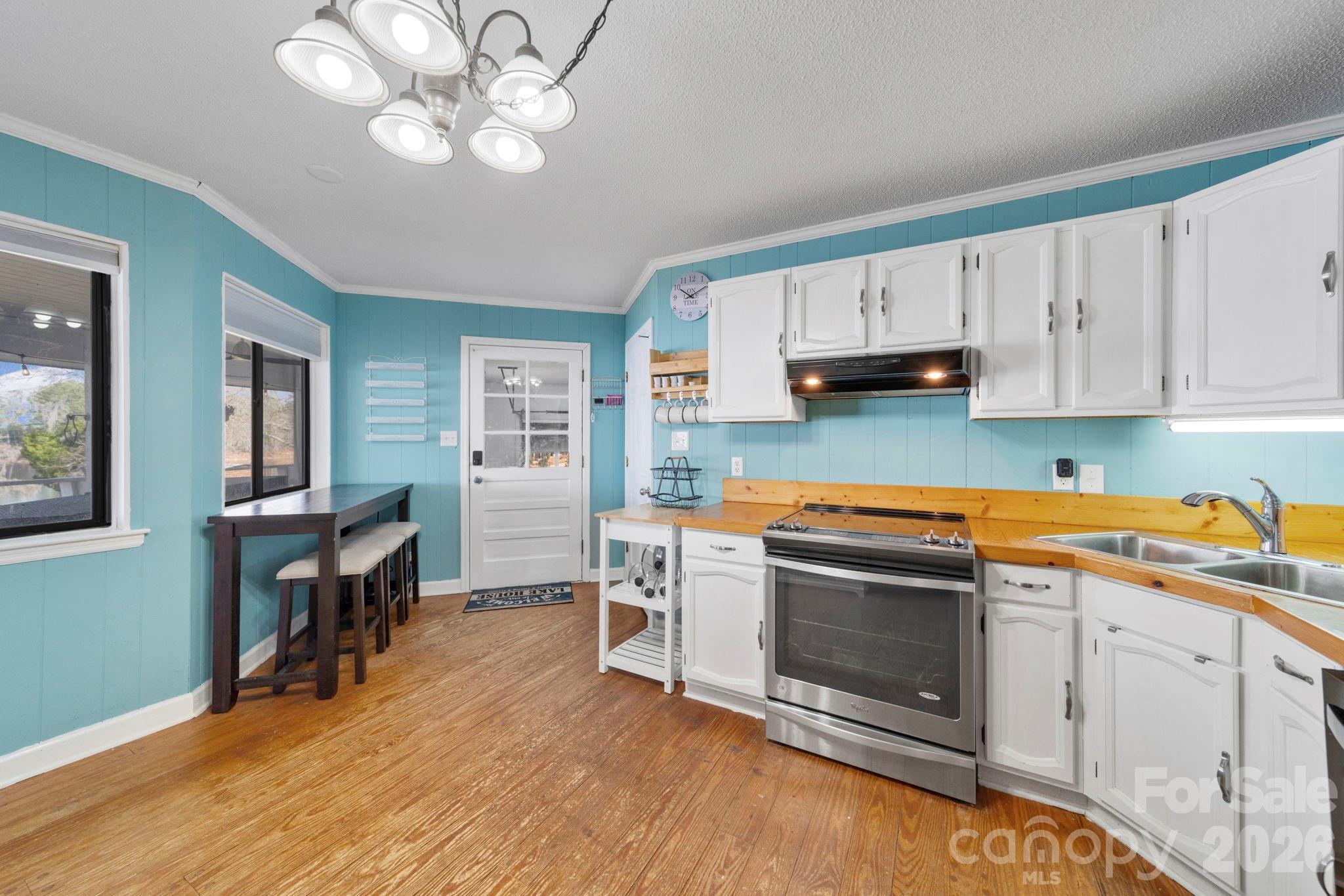 1777 Wild Turkey Road, Unit 23 Camden, SC 29020 - Photo 20 of 45 a kitchen with stainless steel appliances a stove a sink cabinets and a dining table