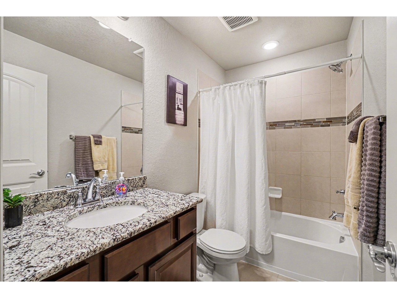 107 South 8th Street Berthoud, CO 80513 - Photo 16 of 22 a bathroom with a granite countertop sink toilet and shower