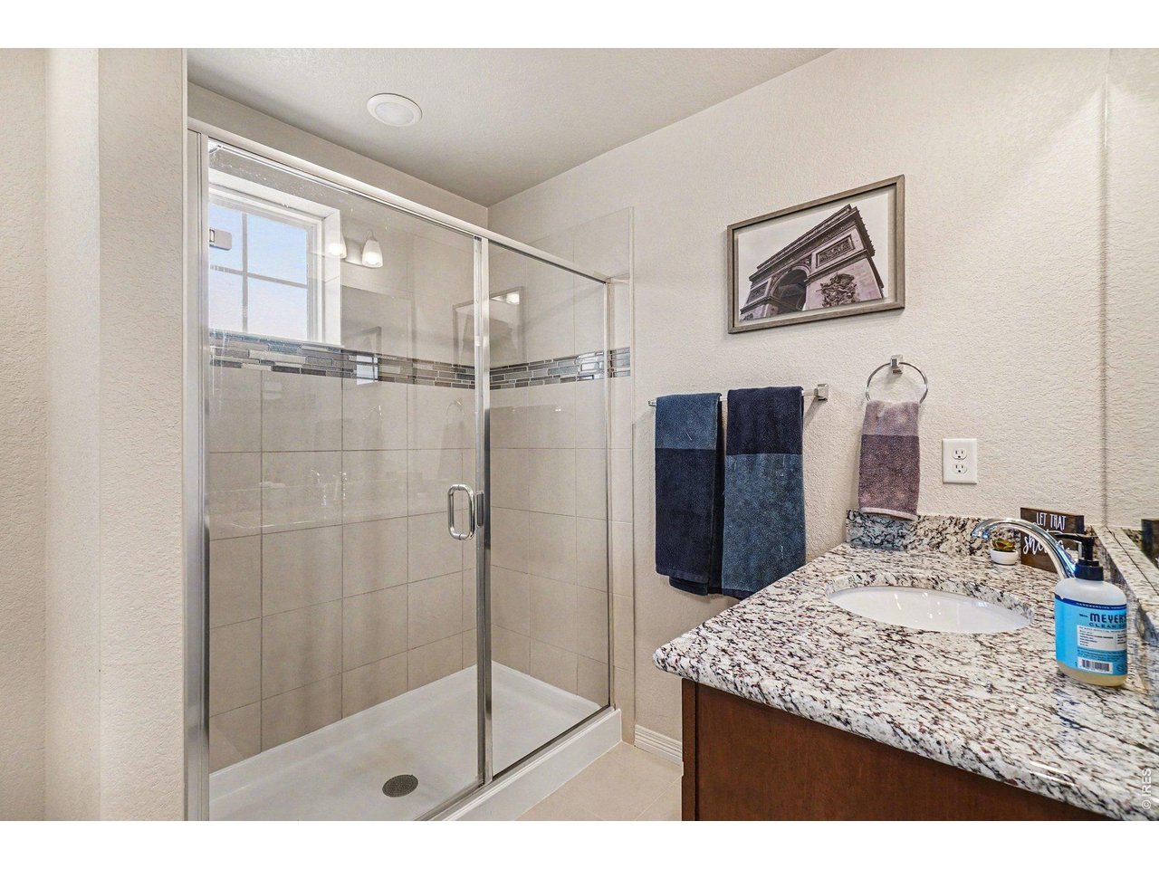 107 South 8th Street Berthoud, CO 80513 - Photo 21 of 22 a bathroom with a granite countertop sink a mirror and shower