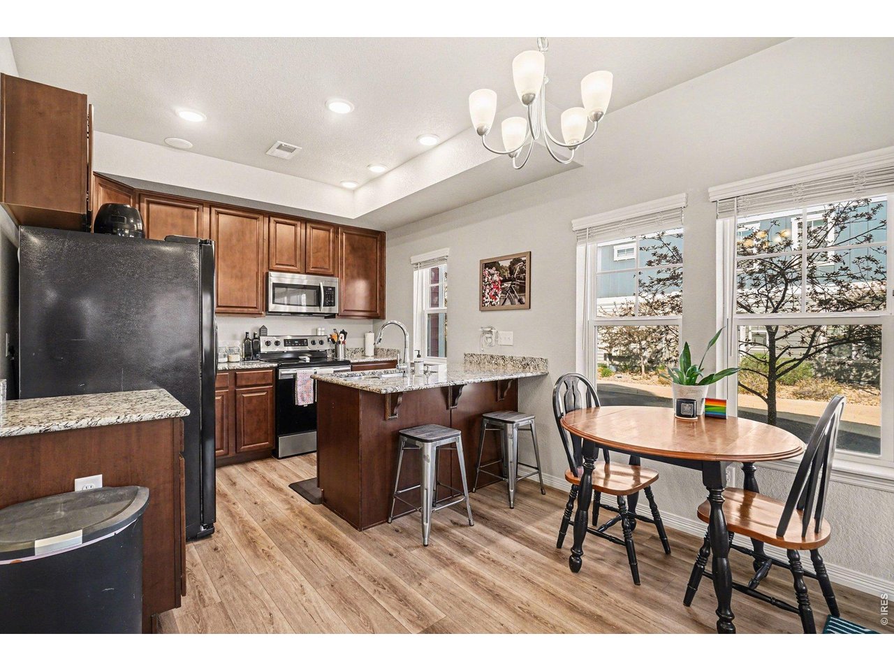 107 South 8th Street Berthoud, CO 80513 - Photo 7 of 22 a open dining room with stainless steel appliances kitchen island granite countertop a table chairs and a refrigerator