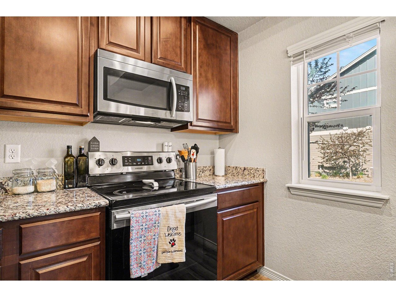 107 South 8th Street Berthoud, CO 80513 - Photo 8 of 22 a kitchen with stainless steel appliances granite countertop a stove microwave and cabinets