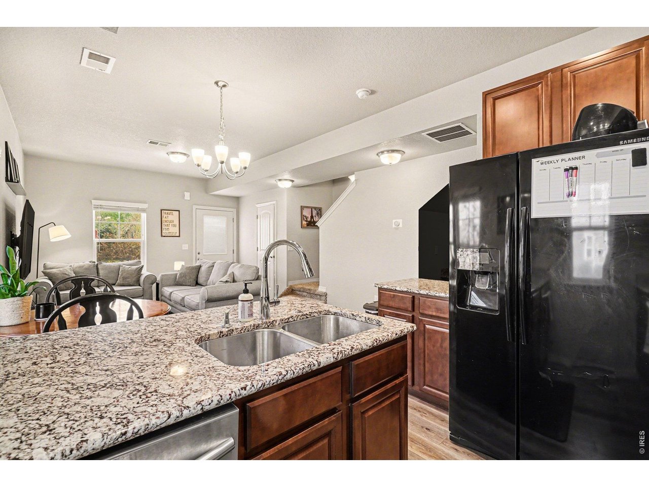 107 South 8th Street Berthoud, CO 80513 - Photo 9 of 22 a kitchen with stainless steel appliances granite countertop a sink refrigerator and cabinets
