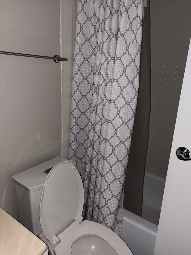 5320 North Sheridan Road, Unit 1407 Chicago, IL 60640 - Photo 21 of 21 a white toilet sitting next to a shower curtain