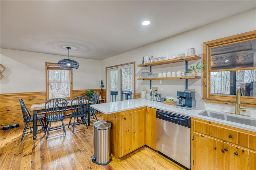 357 Mystic Lane Blue Ridge, GA 30513 - Photo 11 of 58 a kitchen with stainless steel appliances granite countertop a sink dishwasher a dining table and chairs with wooden floor
