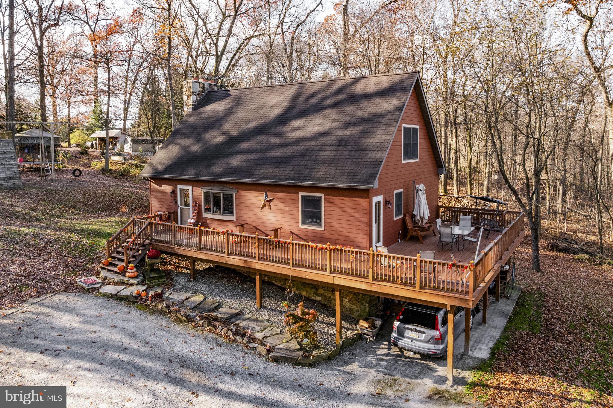 a view of a house with a bed chairs and wooden fence