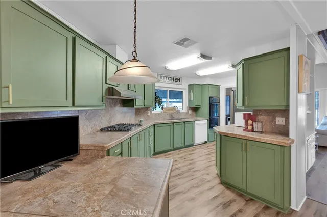 a kitchen with stainless steel appliances kitchen island a refrigerator and a sink