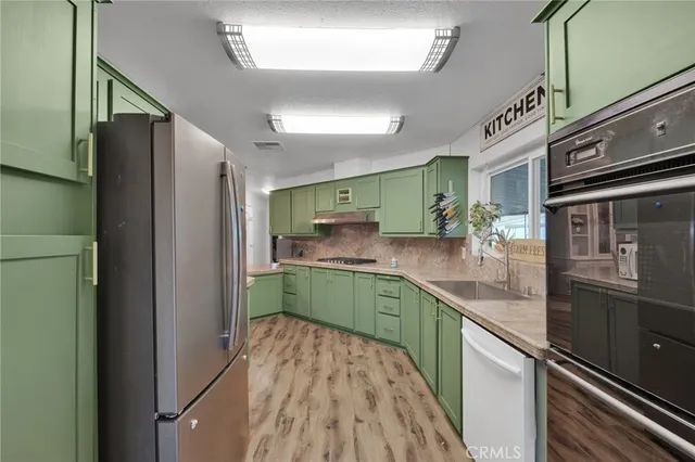 a kitchen with stainless steel appliances granite countertop a refrigerator and a sink