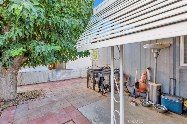 a view of a patio with table and chairs and a barbeque