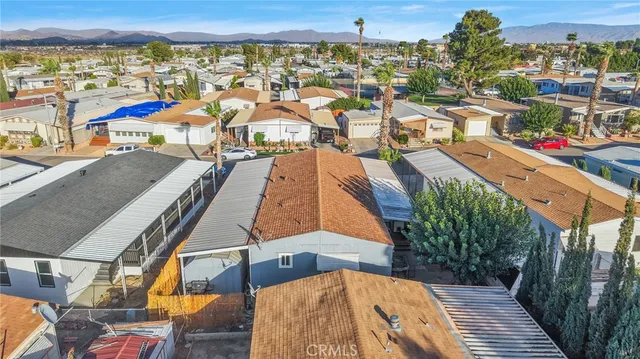 an aerial view of a city with lots of residential buildings and mountain view in back