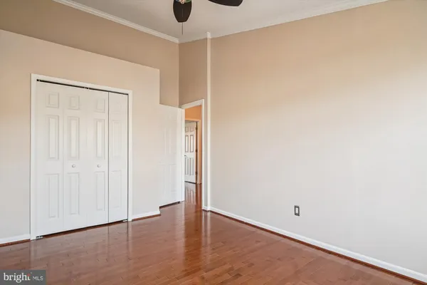 a view of an empty room with wooden floor fireplace and a window