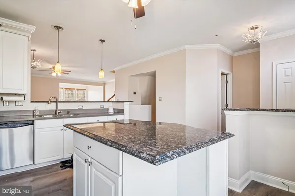 a view of an empty room with wooden floor fireplace and a window