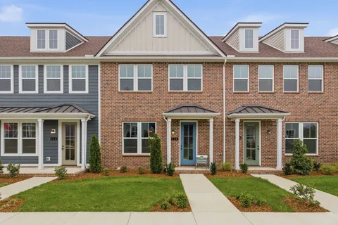 front view of a brick house with a yard